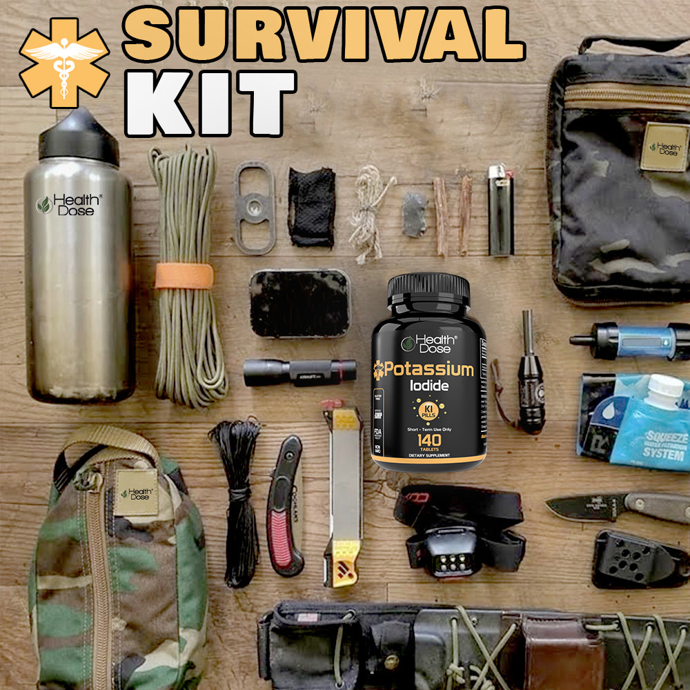 Collection of survival items including a water bottle, knife, and first aid kit on a wooden surface.